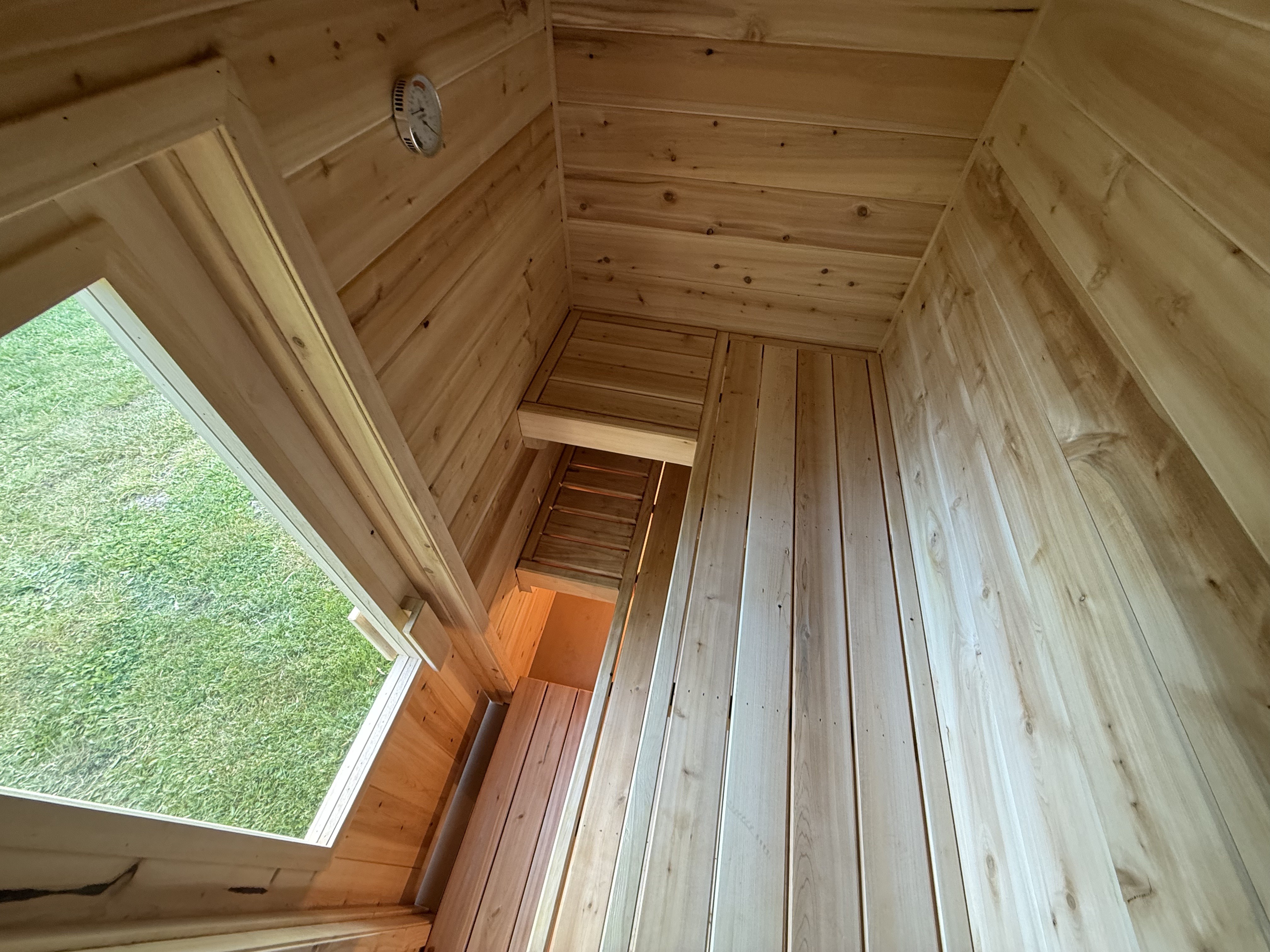 Interior view of cedar bench and window with grass view
